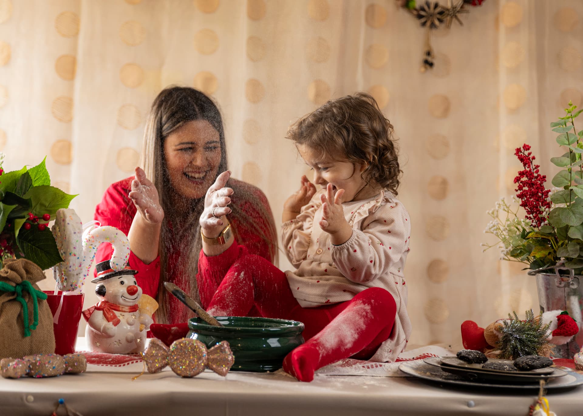 Mãe e filha a brincar à mesa numa sessão de Natal